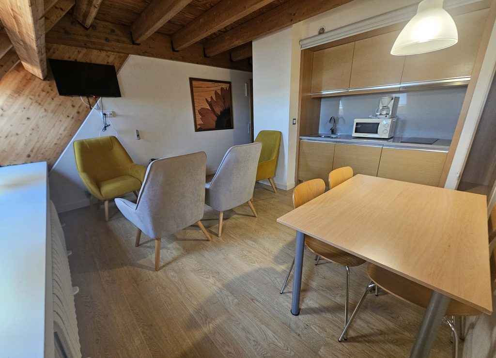 Vista de la sala con mueble auxiliar, mesa y sofás