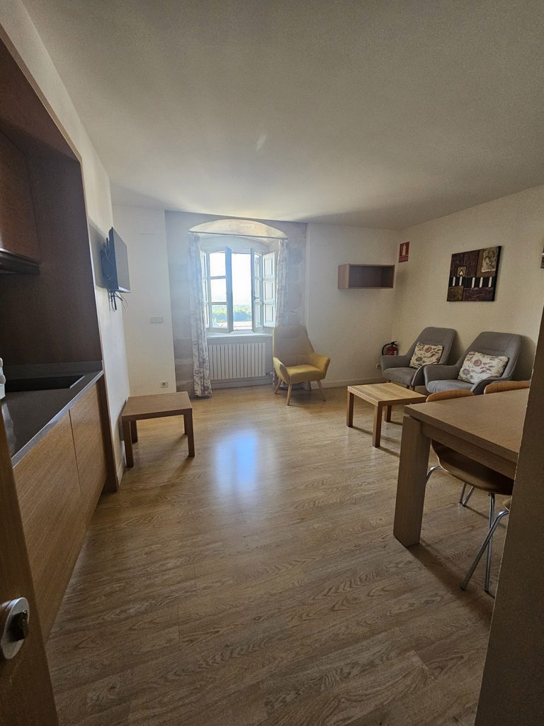 Vista de la sala de estar, con mueble auxiliar, mesa y 3 sofás